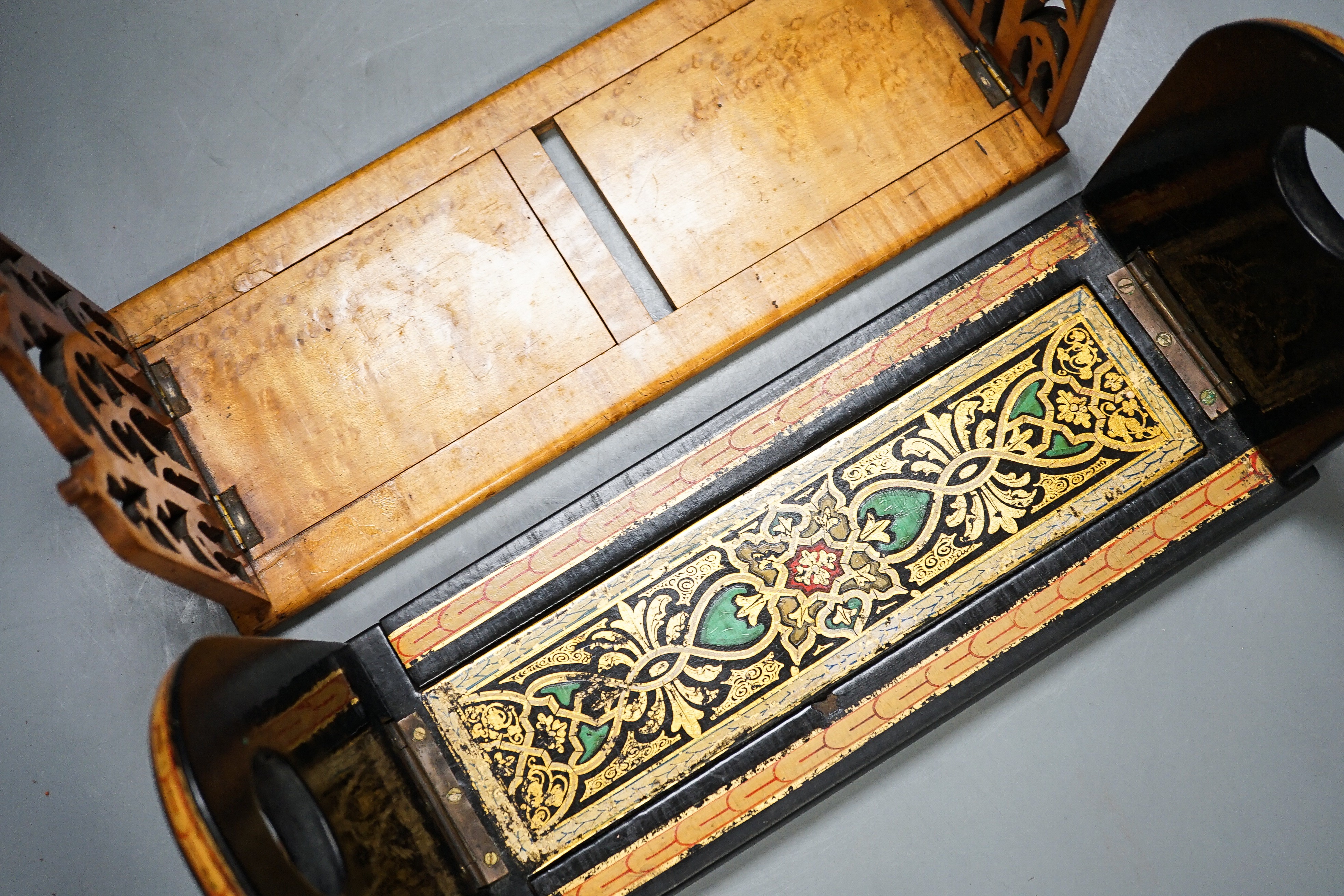 A Victorian Pugin style Gothic revival bird’s eye maple bookslide together with a japanned papier-mâché example (2), largest 34cms wide.